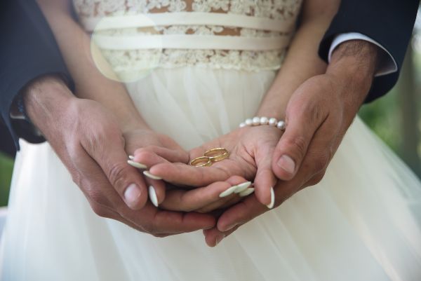 Paquetes de boda; novios sosteniendo anillos de matrimonio en las palmas
